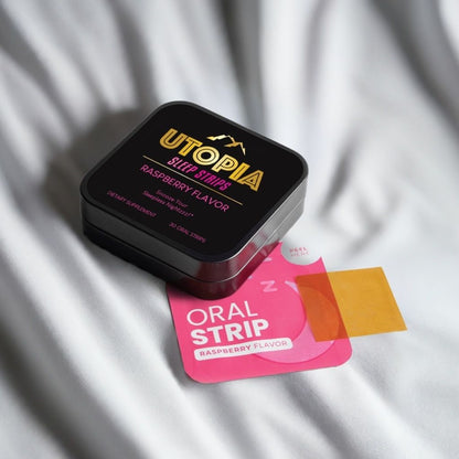 Utopia Sleep Strips raspberry flavor 30-count box and oral strip on a soft white fabric background, highlighting the premium packaging and dissolvable strip for convenient nighttime use.